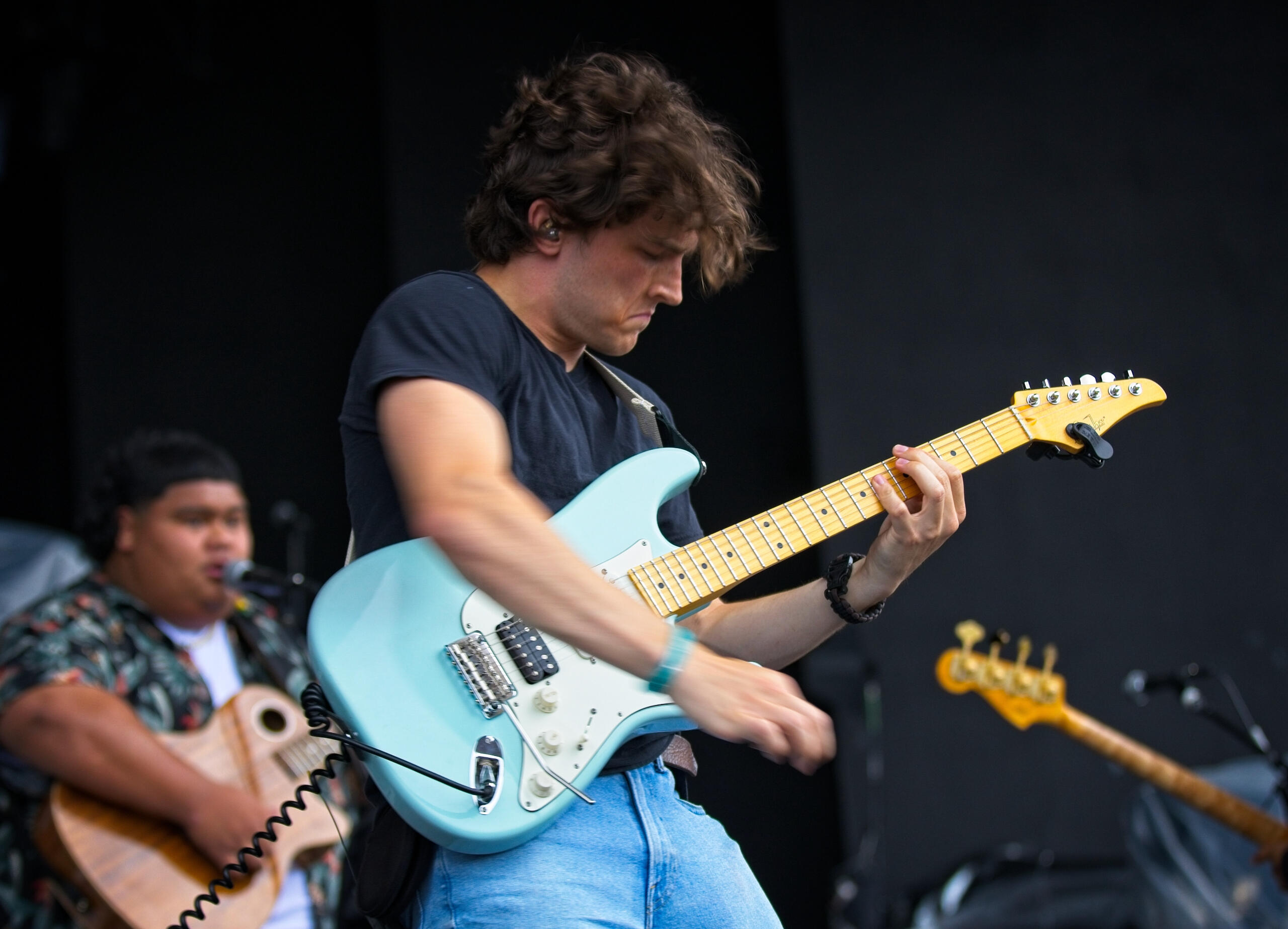 Connor Fiehler playing guitar on stage with 2023 American Idol winner Iam Tongi